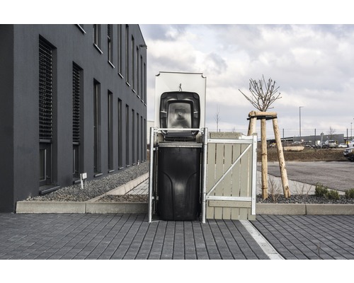 Kontejnerový box s otevřeným víkem před budovou