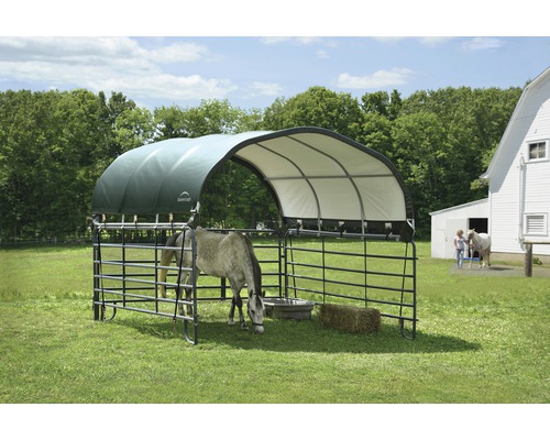 Přístřešek pro koně se střechou a kovovým plotem na louce