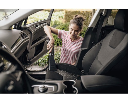 Žena vysává autosedačky vysavačem