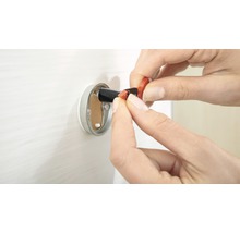 Osoba vkládající elektrický vodič do nástěnné krabice