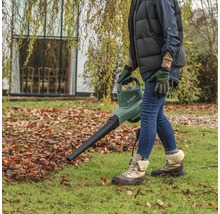 Osoba používá fukar na listí Bosch na zahradě.