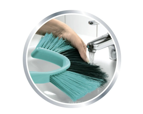 Ruční kartáč na mytí se čistí pod kohoutkem.