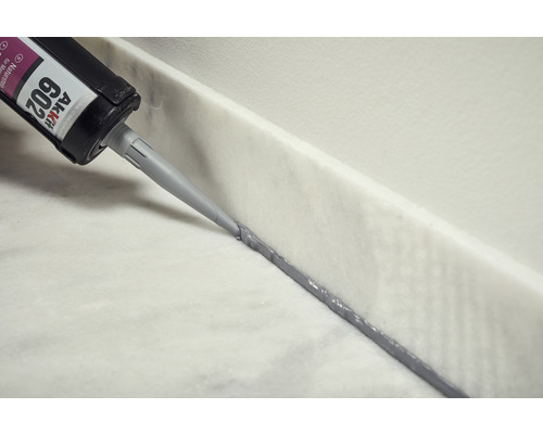 Aplikace přírodního kamenného silikonu z kartuše na mramorový povrch.