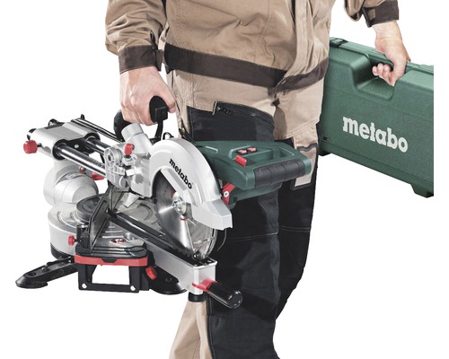 Osoba nese pokosovou pilu Metabo a kufřík na nářadí Metabo.