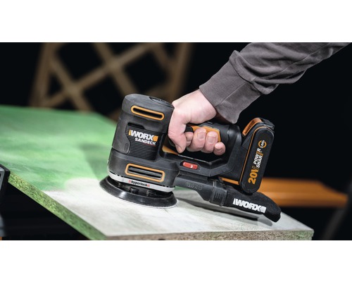 Akumulátorová bruska používaná na dřevěném povrchu.