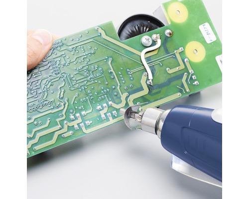 Osoba opravuje desku plošných spojů pomocí páječky.