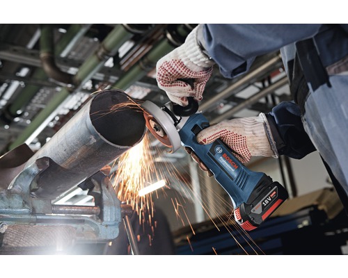 Akumulátorová úhlová bruska používaná při broušení kovové trubky upevněné ve svěráku, logo Bosch