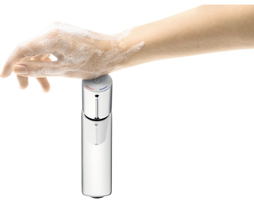 Ruka s mýdlem se dotýká armatury pro odběr vody.