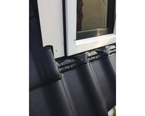 Detailní záběr střešního okna s těsněním na taškové střeše