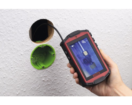 Inspekční kamera se používá k nahlédnutí do otvoru ve zdi.