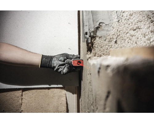 Osoba používá laserovou vodováhu na stěně k vyrovnání projektu.