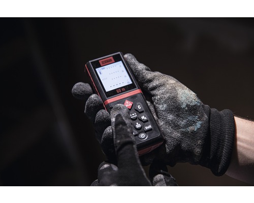 Ruka v pracovní rukavici ovládá laserový dálkoměr s dosahem 60 metrů.