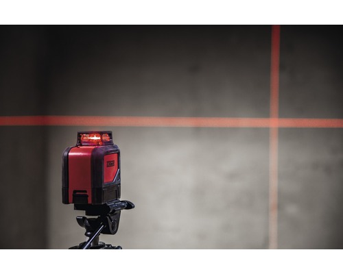 Křížový čárový laser na stativu s laserovými čárami na stěně