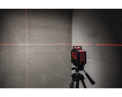 Červený křížový čárový laser na stativu promítá čáry na zeď