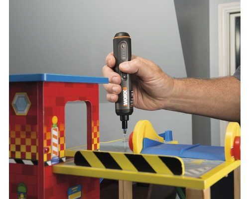 Osoba používá akumulátorový šroubovák na hračce.