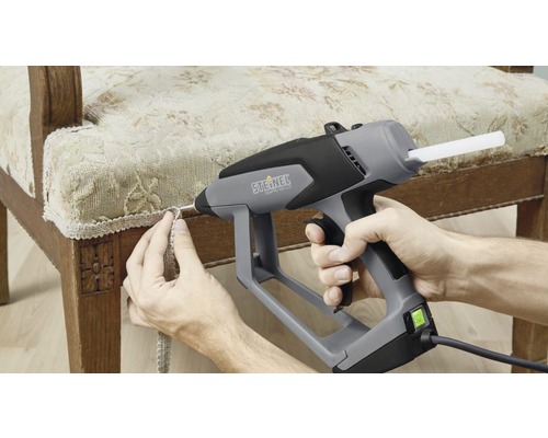 Horkovzdušná pistole připevňuje ozdobnou lištu k židli