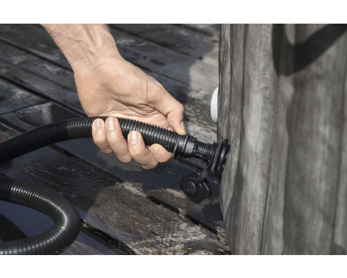 Osoba připojuje hadici k bazénu.