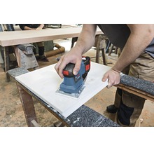 Osoba brousí obrobek elektrickou bruskou.