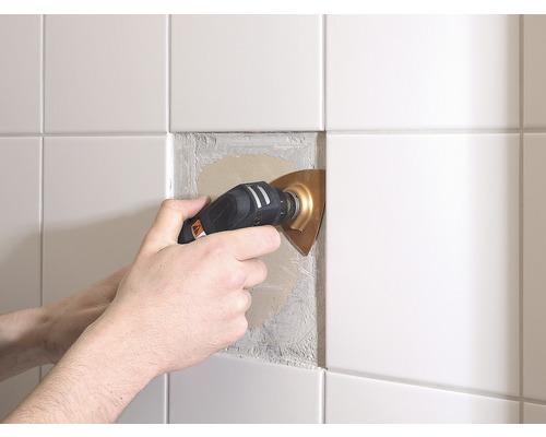 Multifunkční nástroj odstraňuje lepidlo na obklady.