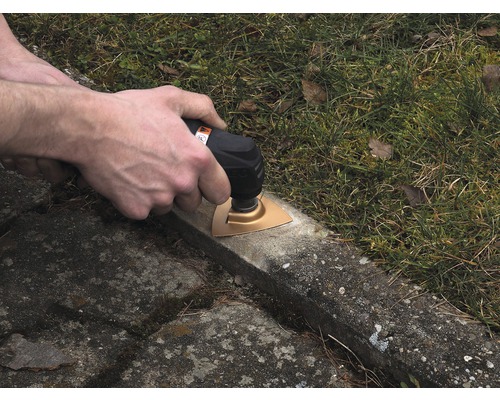 Osoba pracuje s multifunkčním nástrojem na kamenné desce.