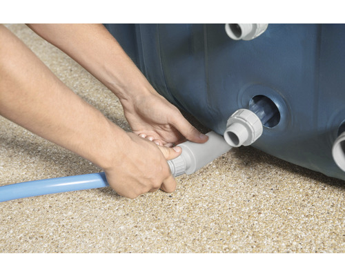 Osoba připojuje bazénovou hadici k bazénu.