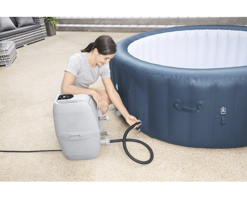 Žena připojuje nafukovací vanu k filtračnímu čerpadlu