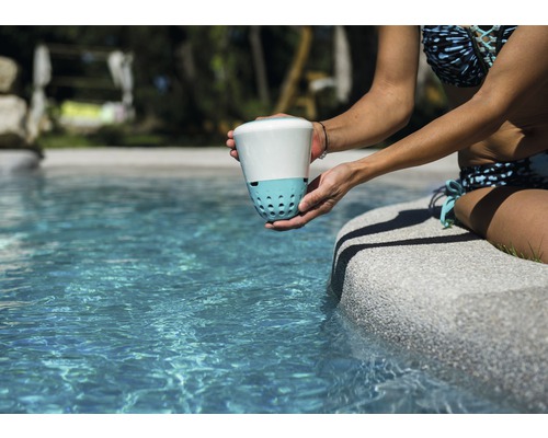 Žena drží dezinfekci vody u okraje bazénu