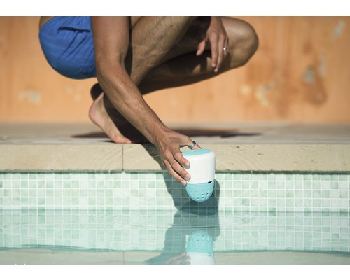 Osoba umisťuje čistič bazénu do bazénu.