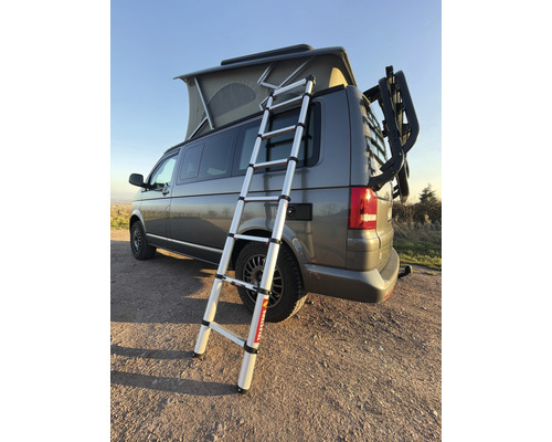 Vysunutý teleskopický žebřík namontovaný na VW bus s nosičem kol.