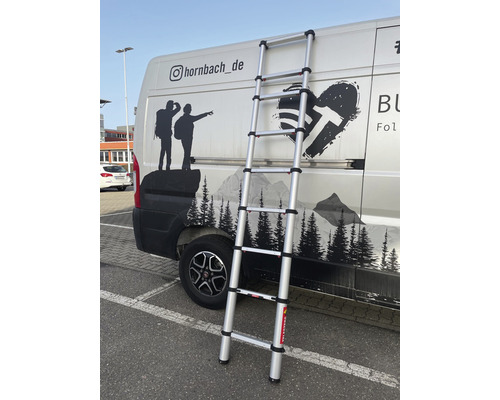 Hliníkový teleskopický žebřík opřený o vozidlo