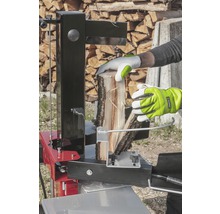 Osoba štípe dříví pomocí štípačky.