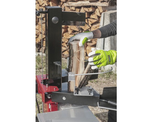 Osoba štípe dříví pomocí štípačky.