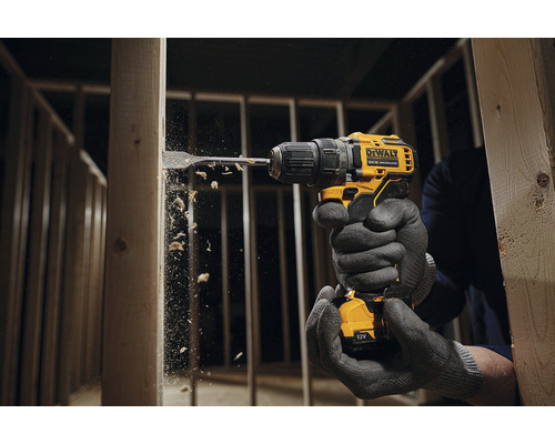 Osoba vrtá vrtačkou DeWalt do dřevěného rámu.