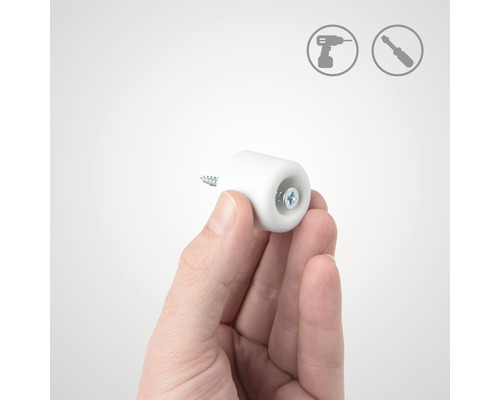 Ruka drží dveřní doraz se šroubem