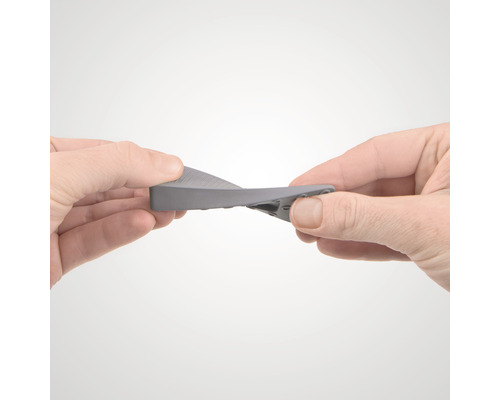 Osoba ohýbá gumový dveřní klín.