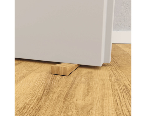 Dřevěný dveřní klín pod dveřmi na dřevěné podlaze