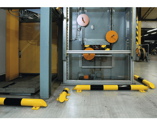 Žlutočerné nárazové profily před výrobním strojem.