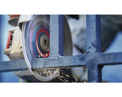 Kovová mřížka je opracovávána úhlovou bruskou, přičemž vznikají jiskry.