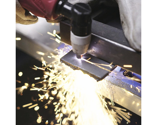 Zpracování kovu plazmovou řezačkou pod jiskrami.