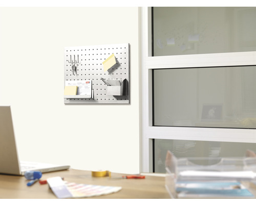 Děrovaná deska namontovaná na stěně s kancelářskými potřebami v kanceláři.