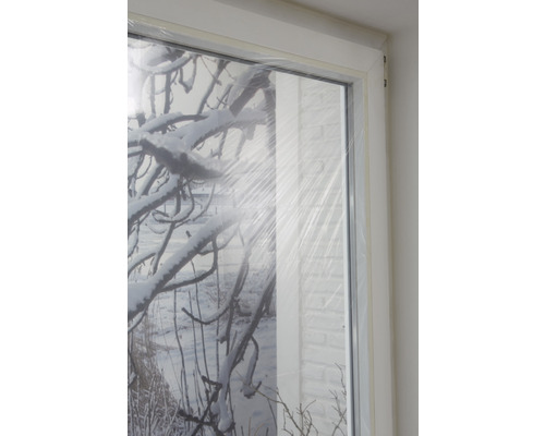 Okno s ochrannou fólií a zimní krajinou v pozadí