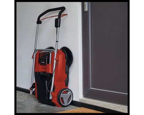 Venkovní zametací stroj opřený o zeď