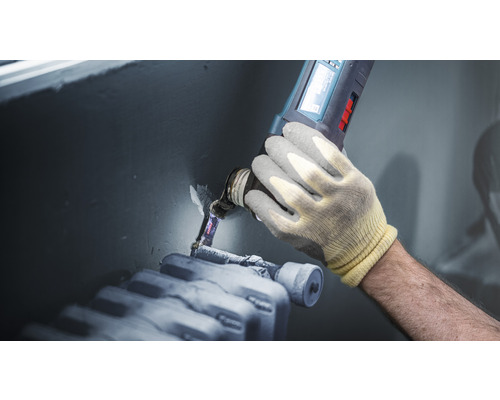 Řemeslník opracovává topenářskou trubku multifunkčním nástrojem