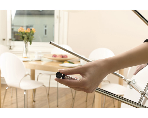 Žena připevňuje plstěný kluzák na nohu židle