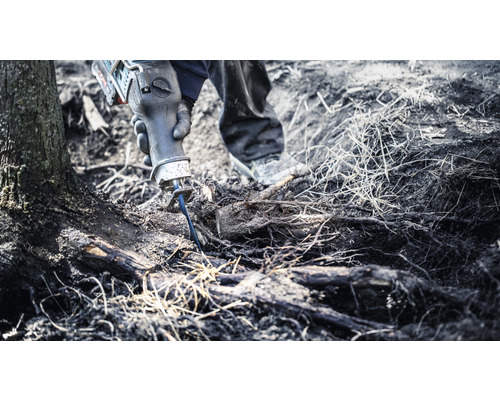 Osoba používá ocasku k řezání kořenů.