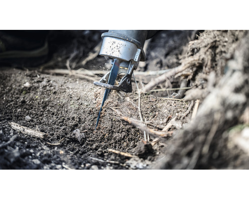 Šavlová pila řeže kořen v zemi.