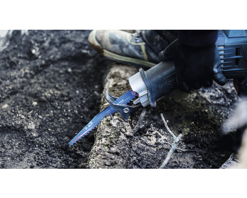 Osoba používá ocasku k řezání dřeva.