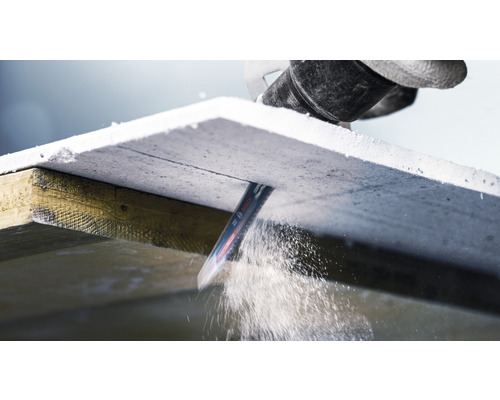 Přímočará pila řeže sádrovláknitou desku na dřevěném rámu.