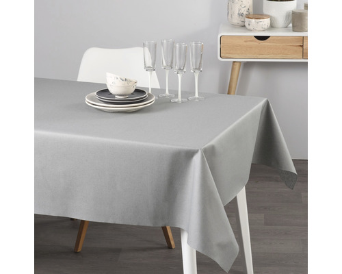 Šedý ubrus na stole s nádobím a sklenicemi.