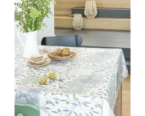 Prostřený stůl s ubrusem s olivovým vzorem, nádobím a dekorací